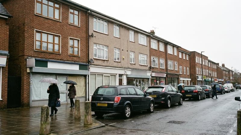 A high-street parade of small shops with two storeys of flats above